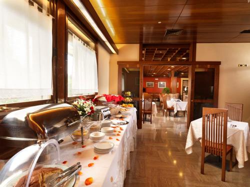 a dining room with a table with white tablecloths at Hotel Al Pino Verde in Camposampiero