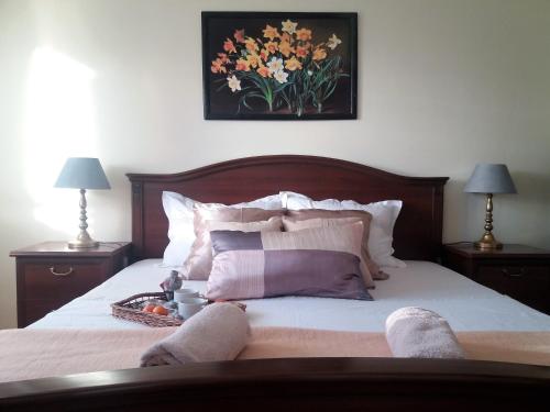 a bedroom with a bed with two lamps and a picture of flowers at Marty Apartment in Rogoznica