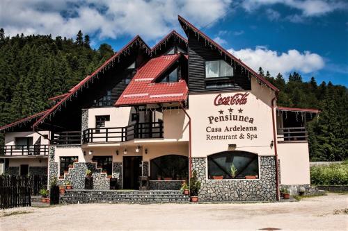 a building with a sign for a restaurant at Casa Ardeleana in Predeal