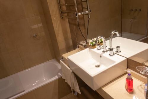 a bathroom with a sink and a shower and a tub at Sathya in San Miguel de Tucumán