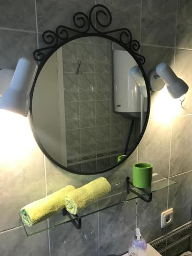 a bathroom with a mirror and a towel on a sink at Kotedžiukai Šventojoje in Šventoji