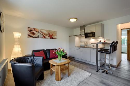 a living room with a couch and a table and a kitchen at Appartementhaus Bergstraße in Prerow