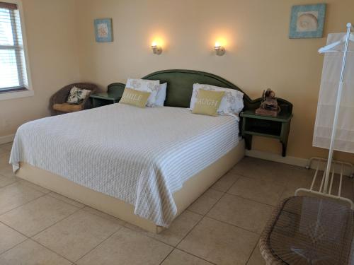 ein Schlafzimmer mit einem großen weißen Bett mit zwei Tischen in der Unterkunft Snappers Key Largo in Key Largo