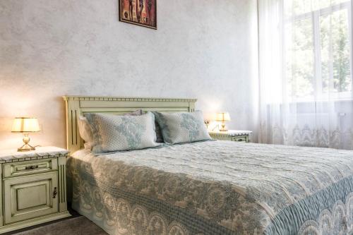 ein Schlafzimmer mit einem Bett und zwei Nachttischen mit Lampen in der Unterkunft Dominicana l Apartments l Lviv Historical City Center in Lwiw