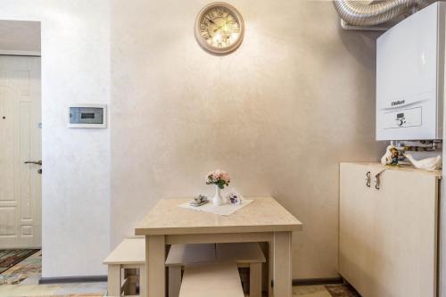 a kitchen with a table and a clock on the wall at Dominicana l Apartments l Lviv Historical City Center in Lviv