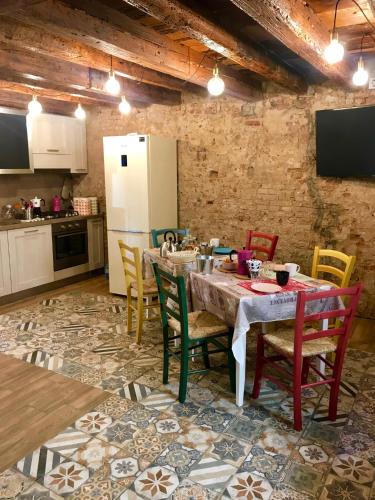 a kitchen with a table with chairs and a refrigerator at Barbara’s rooms in Chioggia