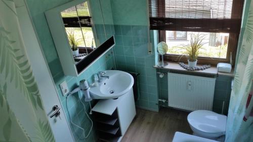 La salle de bains verte est pourvue d'un lavabo et de toilettes. dans l'établissement Räuberhöhle, à Deuselbach