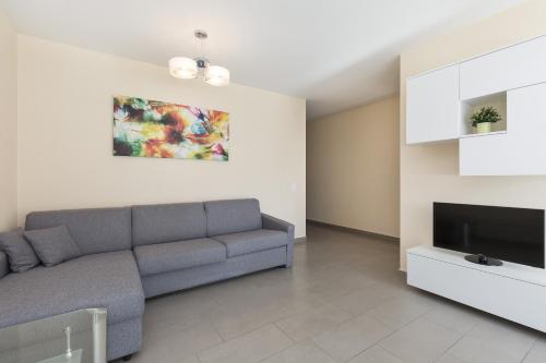 uma sala de estar com um sofá e uma televisão de ecrã plano em Girasole by Quokka 360 - quiet two-bedroom apartment close to the centre em Lugano