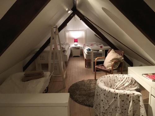 a attic room with a ladder and a bunk bed at Malistorpets Rosor in Varberg