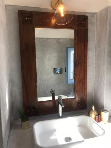 a bathroom with a sink and a large mirror at Le Lanterne Resort in Pantelleria