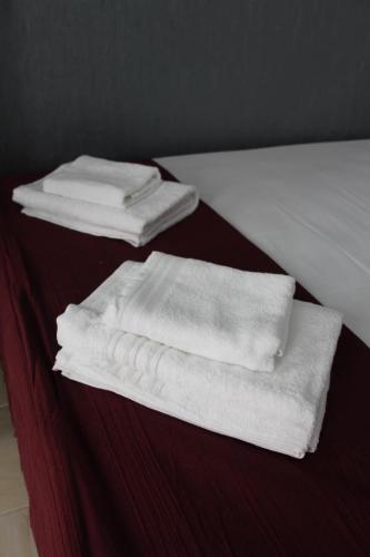 two stacks of towels sitting on top of a bed at Lisbon Prime Hostel & Rooms in Lisbon