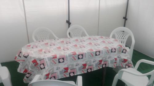 a table with white chairs and a table cloth on it at Casa Castrelo in Retorta