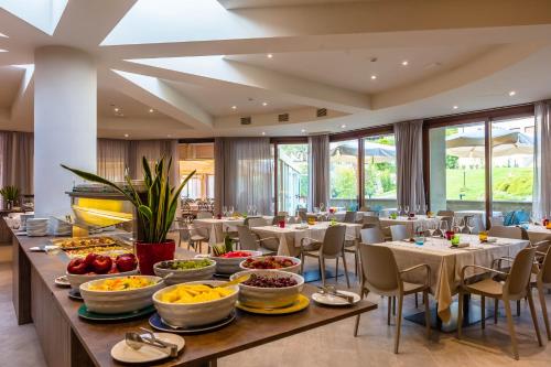 ein Buffettisch mit Schalen an Speisen in einem Restaurant in der Unterkunft Le Torri Del Garda FamilySPA Resort in Torri del Benaco