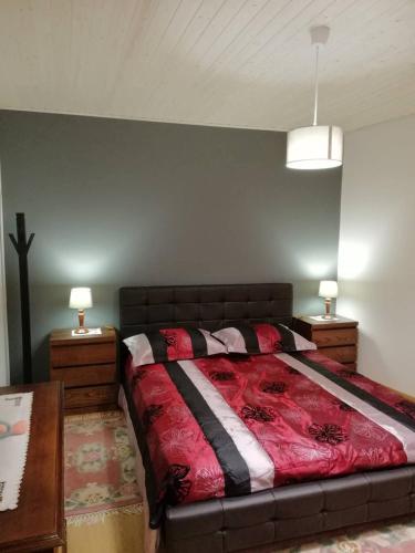 a bed in a bedroom with two night stands and two lamps at Casa do Terreiro in Macedo de Cavaleiros