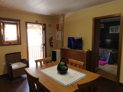 a living room with a dining room table and a television at Casa do Terreiro in Macedo de Cavaleiros