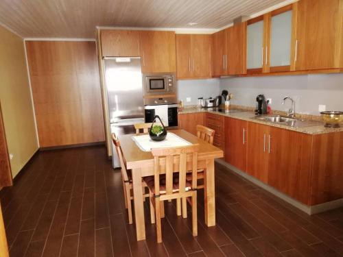 a kitchen with a wooden table and a refrigerator at Casa do Terreiro in Macedo de Cavaleiros