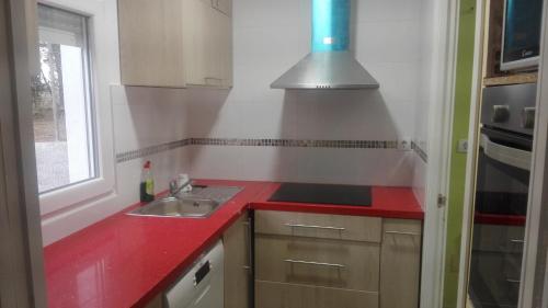 a kitchen with a sink and a red counter top at Casa Castrelo in Retorta