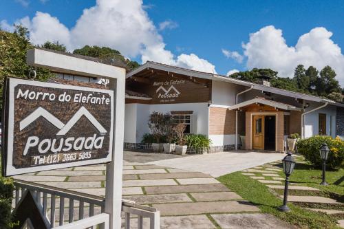 a house with a sign in front of it at Pousada Morro do Elefante in Campos do Jordão