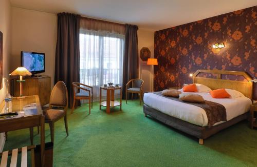 Habitación de hotel con cama, mesa y sillas en Logis Burnel Et La Cle Des Champs en Rouvres-en-Xaintois