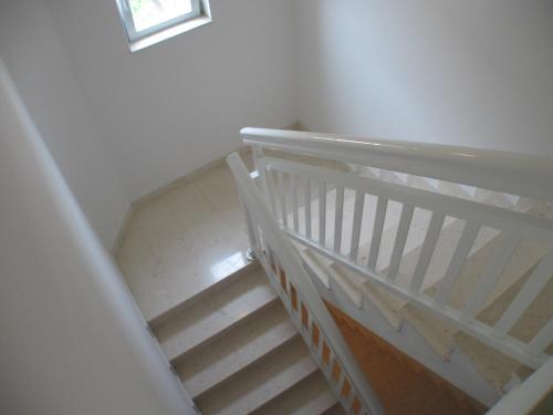 a white staircase with a white railing in a room at Apartments Milas in Trogir