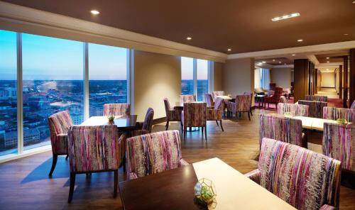a restaurant with tables and chairs and large windows at Fairmont Austin Gold Experience in Austin