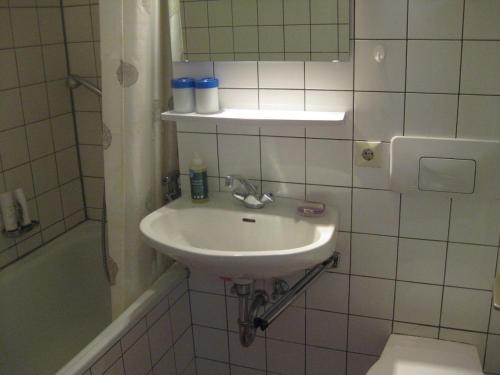uma casa de banho branca com um lavatório e um WC em Koenigs Appartement mit Pool em Schluchsee