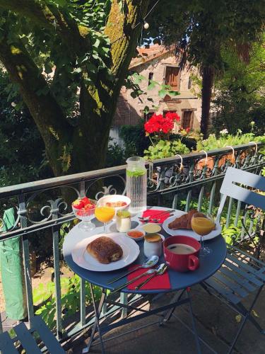 une table avec de la nourriture et des boissons sur un balcon dans l'établissement Auberge Lion D'Or, à Saint-Antonin