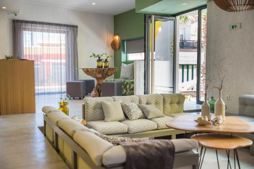 a living room with a couch and a table at Natali Apartments by Estia in Malia