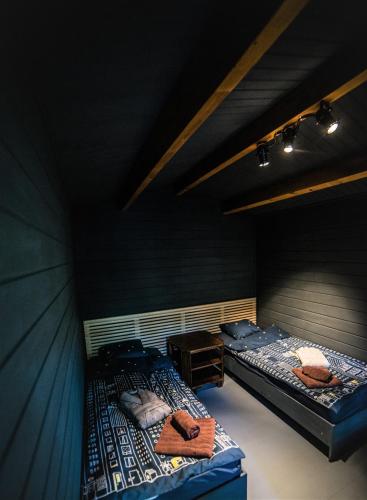 two twin beds in a room with black walls at Enpi Lake Resort in Iaşi