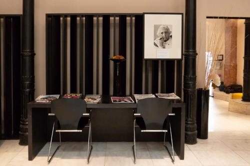 a black table and chairs in a room at Petit Palace Plaza Málaga in Málaga