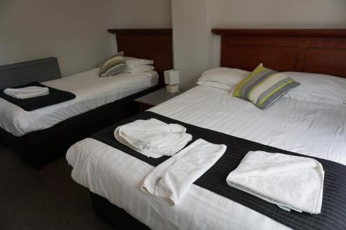 a hotel room with two beds with towels on them at Boreland Lodge Hotel in Inverkeithing