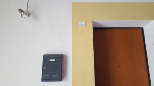 a brown door and a wall with a light at Via Pioppa 24 in Ferrara
