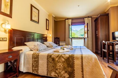 1 dormitorio con 1 cama con mesa y ventana en Hotel Peña Pandos en Felechosa