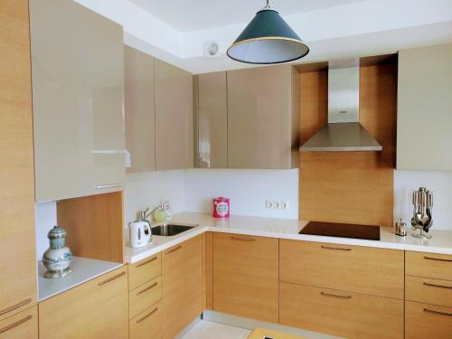 a kitchen with wooden cabinets and aendant light at Peter House in Ventspils