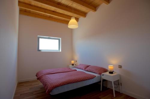 コティージョにあるMolino de el Roqueのベッドルーム1室(赤いシーツとランプ2つ付)