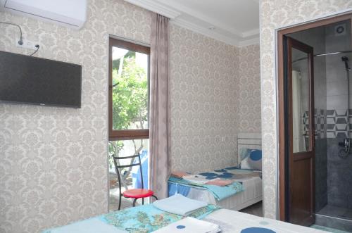 a room with two beds and a window at Kutaisi Best Guest House in Kutaisi