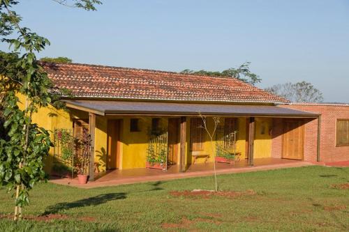 una casa amarilla con techo rojo en Fazenda Santa Teresa Hotel, en Bocaina
