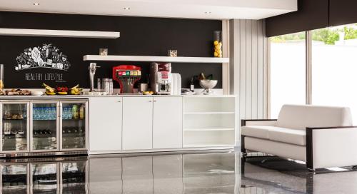 a kitchen with white cabinets and a white chair at Globales Palmanova in Palmanova