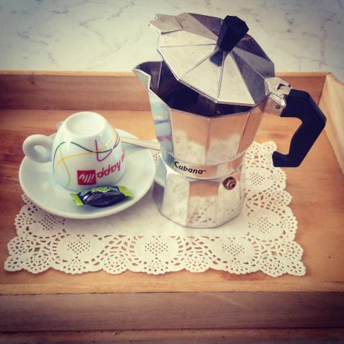 a coffeemaker with an umbrella next to a cup and a plate at Aria di Casa Country Resort in Alberobello