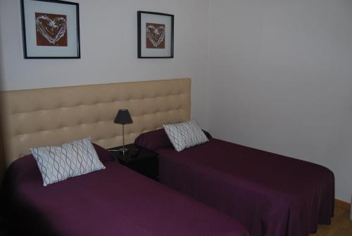 two beds sitting next to each other in a bedroom at Aparthotel Encasa in Madrid