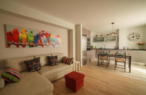 uma sala de estar com um sofá e uma cozinha em Carlota em Alicante