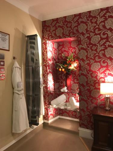 a room with a mirror and a red wall at Beaufort Hotel in Inverness