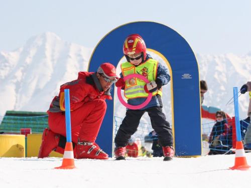 a man and a young boy on skis in the snow at Hotel Babymio in Kirchdorf in Tirol