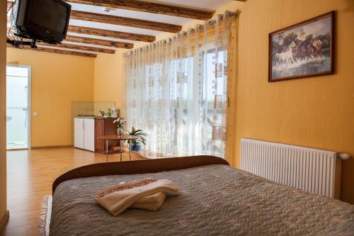 a bedroom with a bed and a tv and a window at Vila Sraige in Palanga