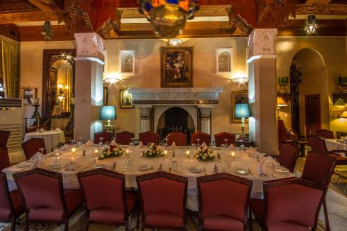 a table in a room with chairs and a fireplace at Palais Dar Donab in Marrakesh