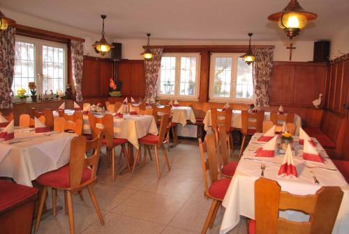a restaurant with tables and chairs with white tablecloths at Gasthof-Landhotel-Metzgerei Zum Stern in Rüdenau