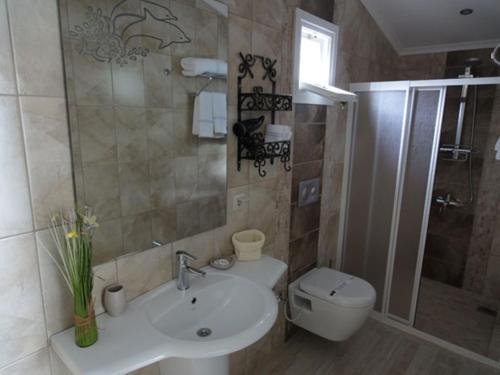 a bathroom with a sink and a toilet at Losta Sahil Evi - Adults Only +12 in Selimiye