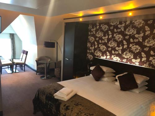 a bedroom with a large bed with a floral wallpaper at The BlueBell Hotel in Neath