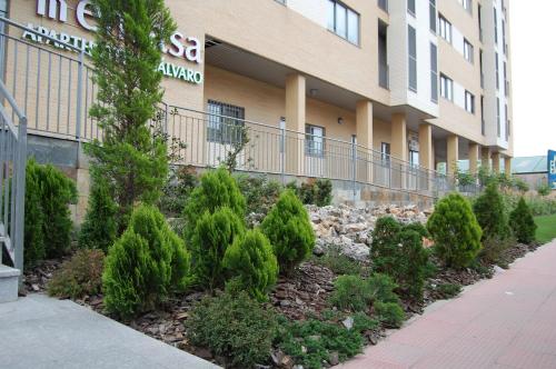 a building with trees in front of a building at Aparthotel Encasa in Madrid