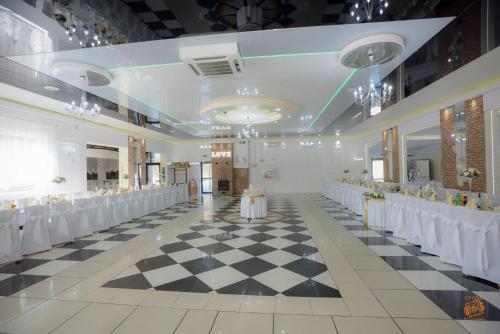 a banquet hall with a checkered floor and white tables at Hotel Zajazdu w Ostrzeszowie in Ostrzeszów